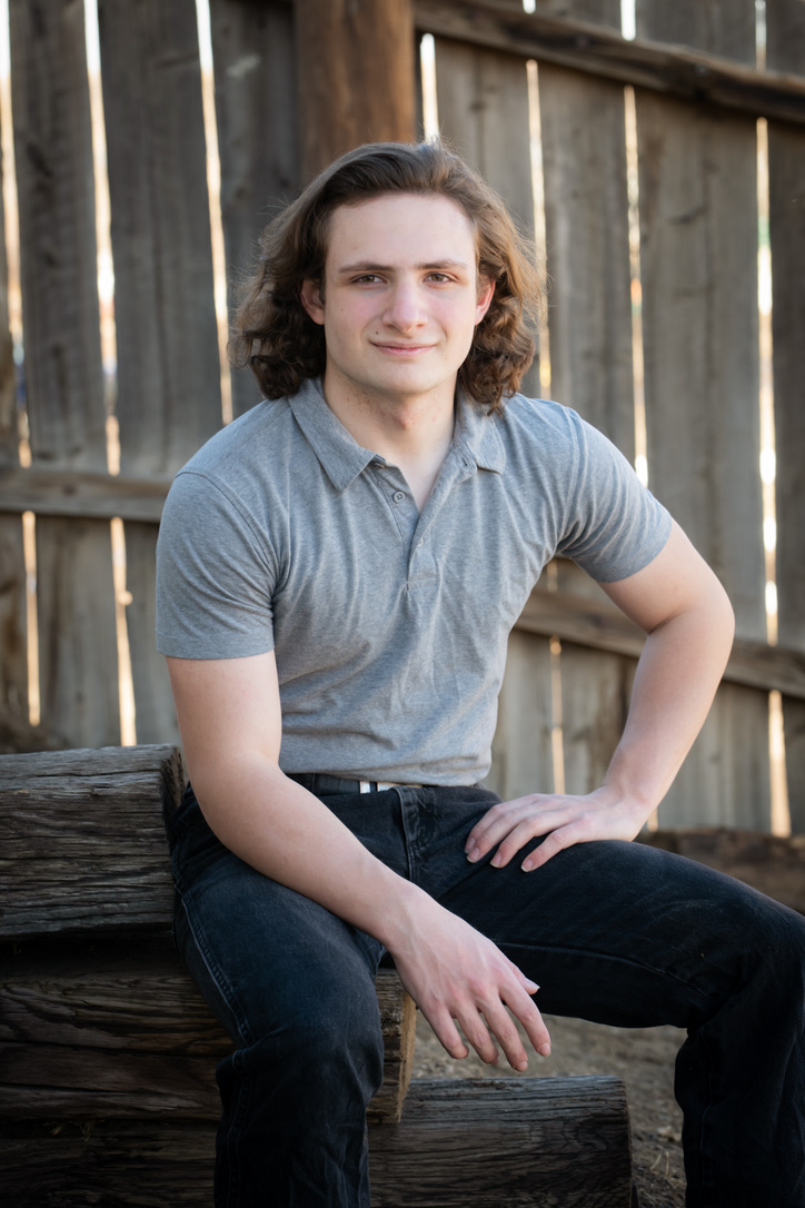 Robert O'Bryan seated outdoors in a portrait taken ahead of graduation.